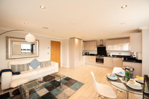a living room with a couch and a table with chairs at Malthouse Court in Reading