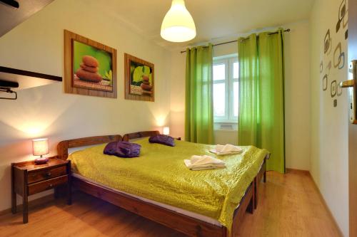 sypialnia z łóżkiem z zielonymi zasłonami i oknem w obiekcie Klimatyczne Apartamenty Sun Seasons 24 w Szklarskiej Porębie by Noclegi Renters w Szklarskiej Porębie