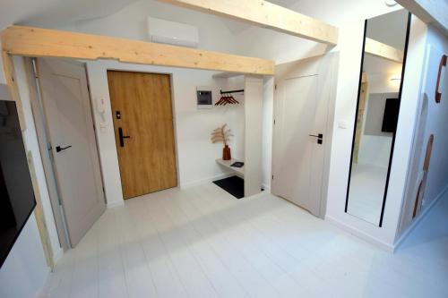 a hallway with a wooden door in a room at Apartamenty Blanca in Łeba