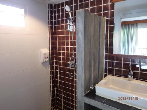 a bathroom with a sink and a shower at Suksompong Resort in Khao Lak