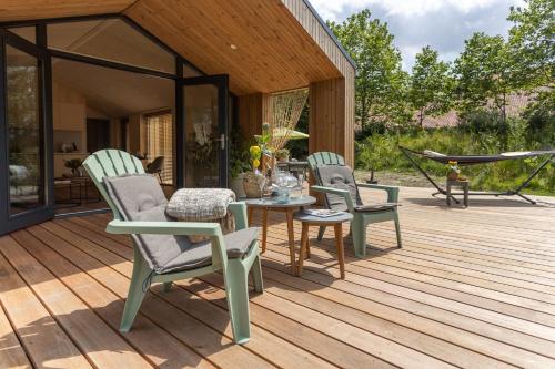 a patio with chairs and a table on a deck at NEW Hello Zeeland - Watervliet Oyster Lodge in Wissenkerke