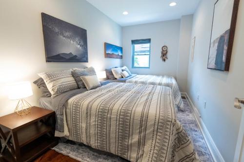 een slaapkamer met twee bedden en een nachtkastje bij Stylish 3BR w Pool Table & Garage in Philadelphia