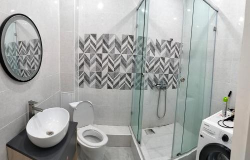 un baño con inodoro y ducha de cristal en 2ком Евро Батыс2, en Aktobe