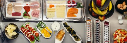 a table topped with trays of different types of food at SmartStay Hotel Pumpengasse in Wolfsburg