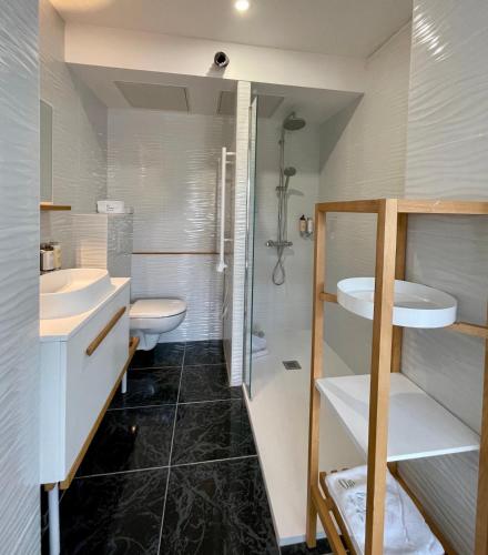 une salle de bain avec toilettes, lavabo et douche dans l'établissement Le 36 Maison d'hôtes Piscine & Spa, à La Flotte