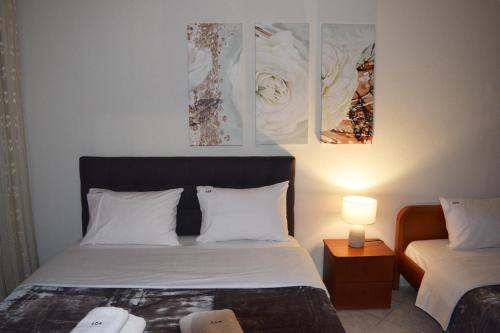 a hotel room with a bed and a lamp and paintings at Aegean Dreams Villa Palio in Paleo Tsifliki
