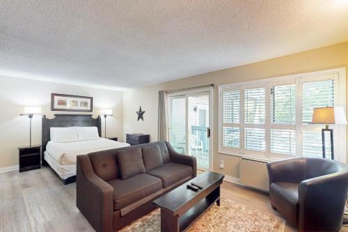 a bedroom with a bed and a couch and a chair at Condo 206 at North Creek Resort in Blue Mountains