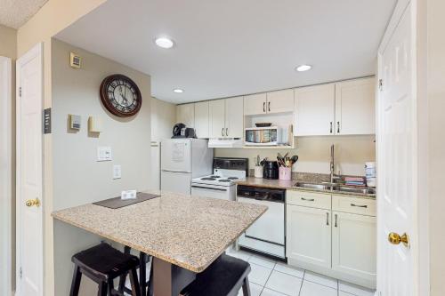 a kitchen with white cabinets and a counter with stools at Condo 206 at North Creek Resort in Blue Mountains