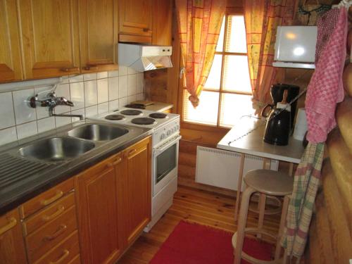 a small kitchen with a sink and a stove at Menninkäinen Cottage in Rutalahti