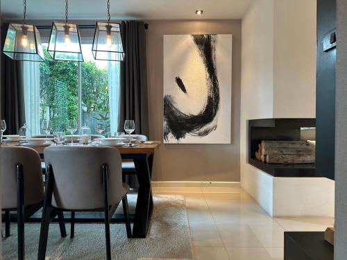 a dining room with a table and a fireplace at Metthods living in Ban Fon