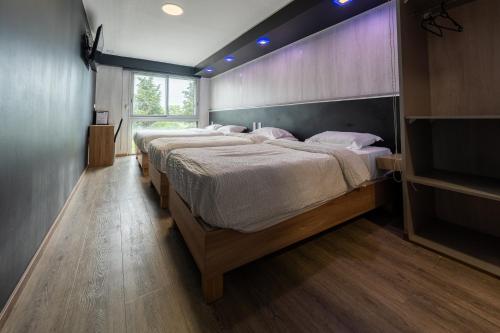 a group of four beds in a room at Hôtel La Rocade in Pamiers