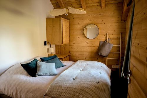 une chambre avec un grand lit avec des oreillers bleus dans l'établissement Blanc Marine, à Villard-Reculas