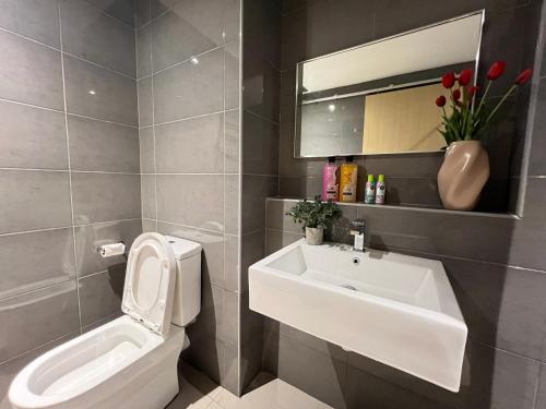 une salle de bain avec un lavabo, des toilettes et un miroir dans l'établissement OceanBay Seaview 6PAX Studio Netflix A-19-13, à Kuantan