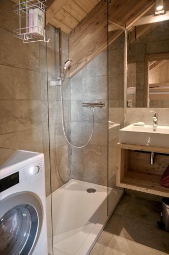 une salle de bain avec une machine à laver et un lavabo dans l'établissement Blanc Marine, à Villard-Reculas