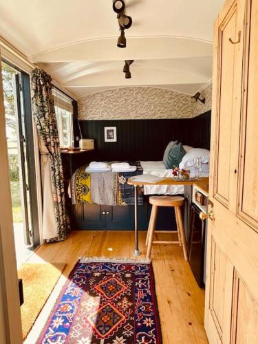 a small room with a table and a bed at The Field Room - Hut on The Lizard in Helston