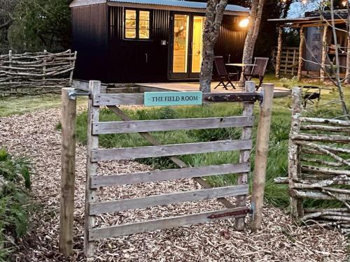 a gate to a tiny house with a sign on it at The Field Room - Hut on The Lizard in Helston