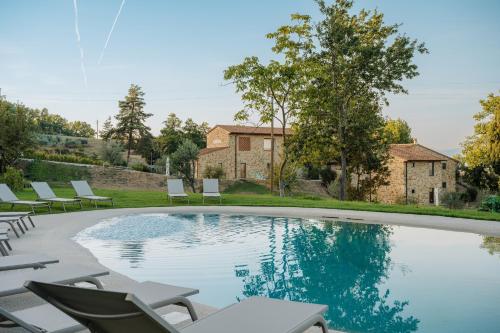 a swimming pool with lounge chairs and a house at Podere di Moiata in Campestri