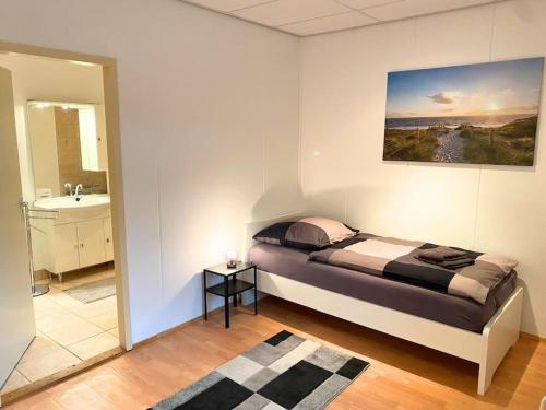 Un dormitorio con una cama y un baño con lavabo. en For Workers Bedburg Hau, en Hau