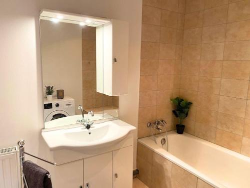 a bathroom with a sink and a tub and a mirror at For Workers Bedburg Hau in Bedburg Hau