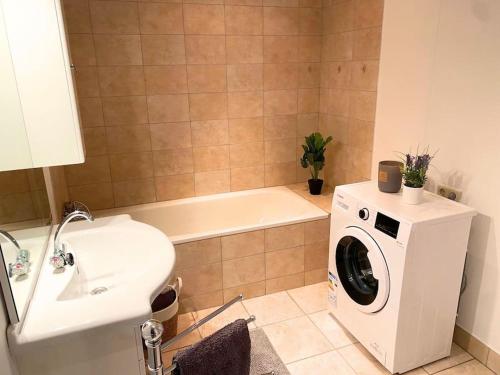 a bathroom with a washing machine next to a sink at For Workers Bedburg Hau in Bedburg Hau