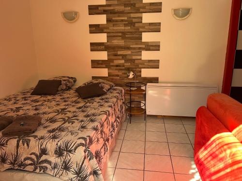 a bedroom with a bed and a brick wall at Rêves de vie le "figuerolles" avec terrasse et parking privés in Cassis