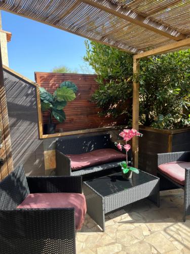 a patio with chairs and a table and a pergola at Rêves de vie le "figuerolles" avec terrasse et parking privés in Cassis