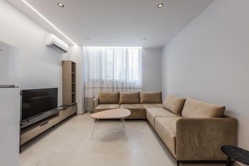a living room with a couch and a tv at SR Apartments Golem in Golem