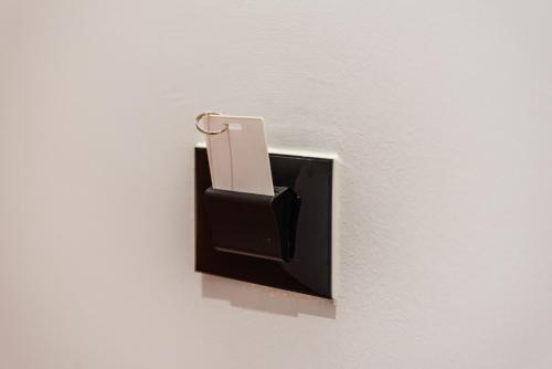a switch on a wall with a cell phone in it at SR Apartments Golem in Golem