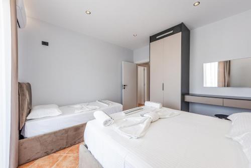 a bedroom with two beds and a mirror at SR Apartments Golem in Golem