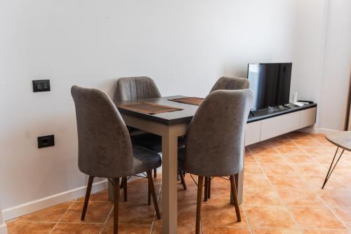 a dining room table with chairs and a television at SR Apartments Golem in Golem