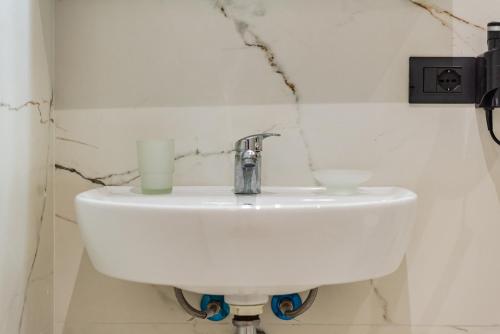 a white sink in a bathroom with a candle at SR Apartments Golem in Golem