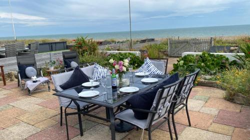a black table and chairs with a view of the ocean at Fisherman's Croft Your Dream Getaway Awaits in Pevensey