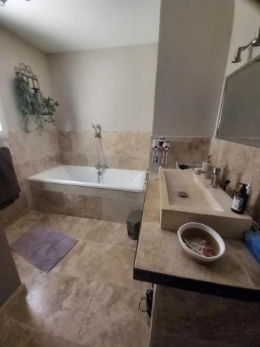 une salle de bain avec une baignoire et un lavabo dans l'établissement Maison de plein pied avec vue sur le Lubéron, à Maubec