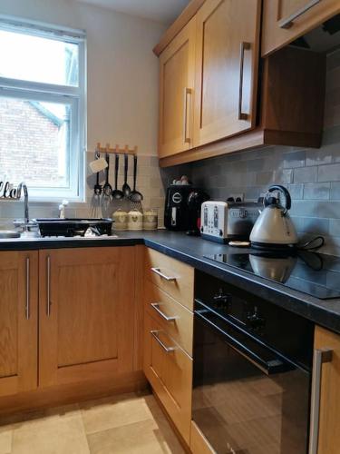 a kitchen with wooden cabinets and a tea kettle at Aqua View, New Brighton Beach- 2 Bedroom with BALCONY & VIEW in New Brighton