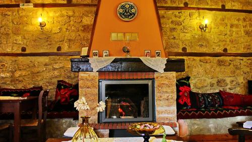 a living room with a fireplace in a stone wall at Varosi Guesthouse in Edessa