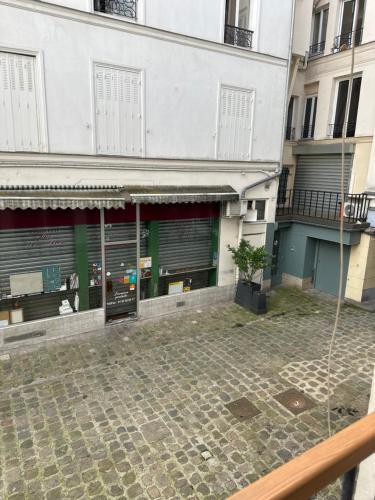 - une vue sur l'extérieur d'un bâtiment avec une cour dans l'établissement Évasion Parisienne !, à Paris