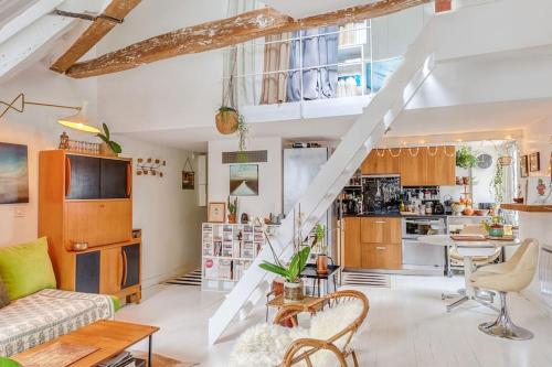 un salon avec un escalier et une cuisine dans l'établissement Bastille Duplex sous les Toits, à Paris