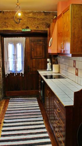 a kitchen with wooden cabinets and a counter top at Varosi Guesthouse in Edessa
