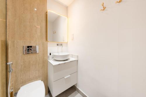 a bathroom with a white toilet and a sink at What a view - very close to DMCC metro station in Dubai