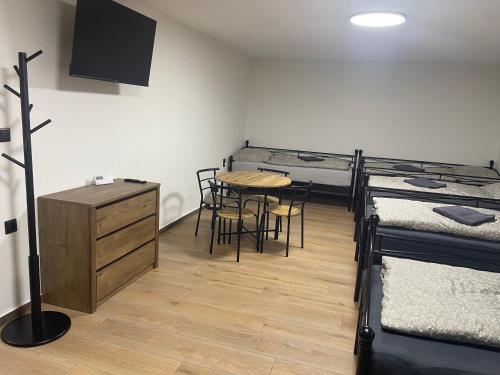 a room with three bunk beds and a table and chairs at Hostel u Arény in Ostrava