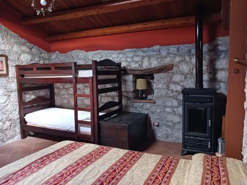 a bedroom with bunk beds and a wood stove at Casa vacanze San Giorgio in Alcara li Fusi