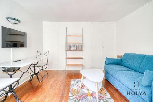 un salon avec un canapé bleu et une table dans l'établissement Proche des Champs Élysées - Le Fonctionnel - 244B, à Paris