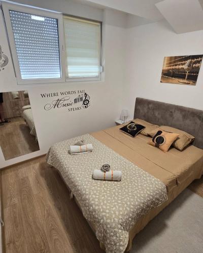 a bedroom with a bed with two pillows on it at Apartman Muzika Jagodina in Jagodina