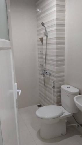 a white bathroom with a toilet and a shower at Keygalaxy in Majalengka