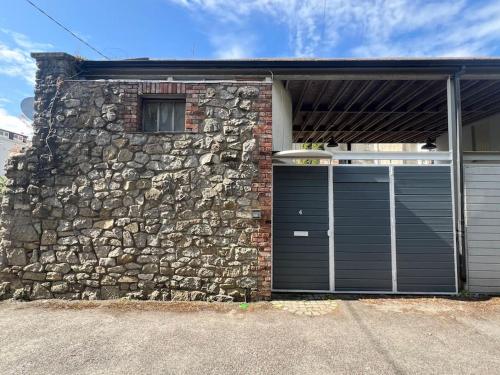 a brick building with a garage with a stone wall at Hideaway Garden Paradise in Dublin
