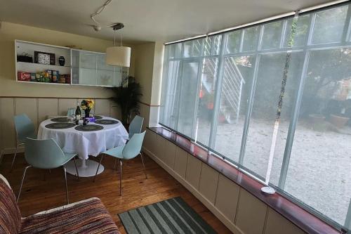 a dining room with a table and a large window at Hideaway Garden Paradise in Dublin