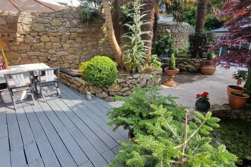 a patio with a table and a stone wall at Hideaway Garden Paradise in Dublin