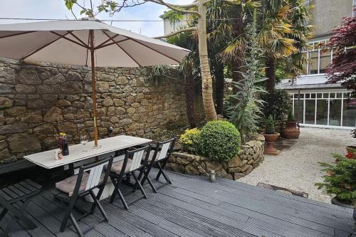 a table and chairs with an umbrella on a deck at Hideaway Garden Paradise in Dublin