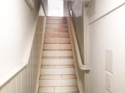 a staircase in a hallway with white tile floors at Top city center location by Airhome in Zug