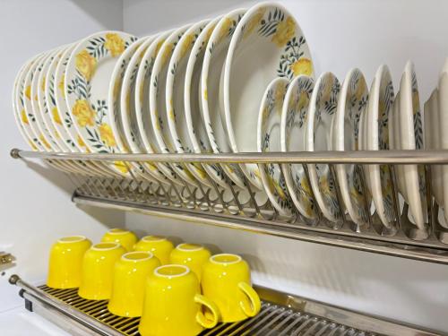 a row of yellow cups and plates on a rack at Casa colonial jacuzzi cerca al parque principal in Santa Fe de Antioquia